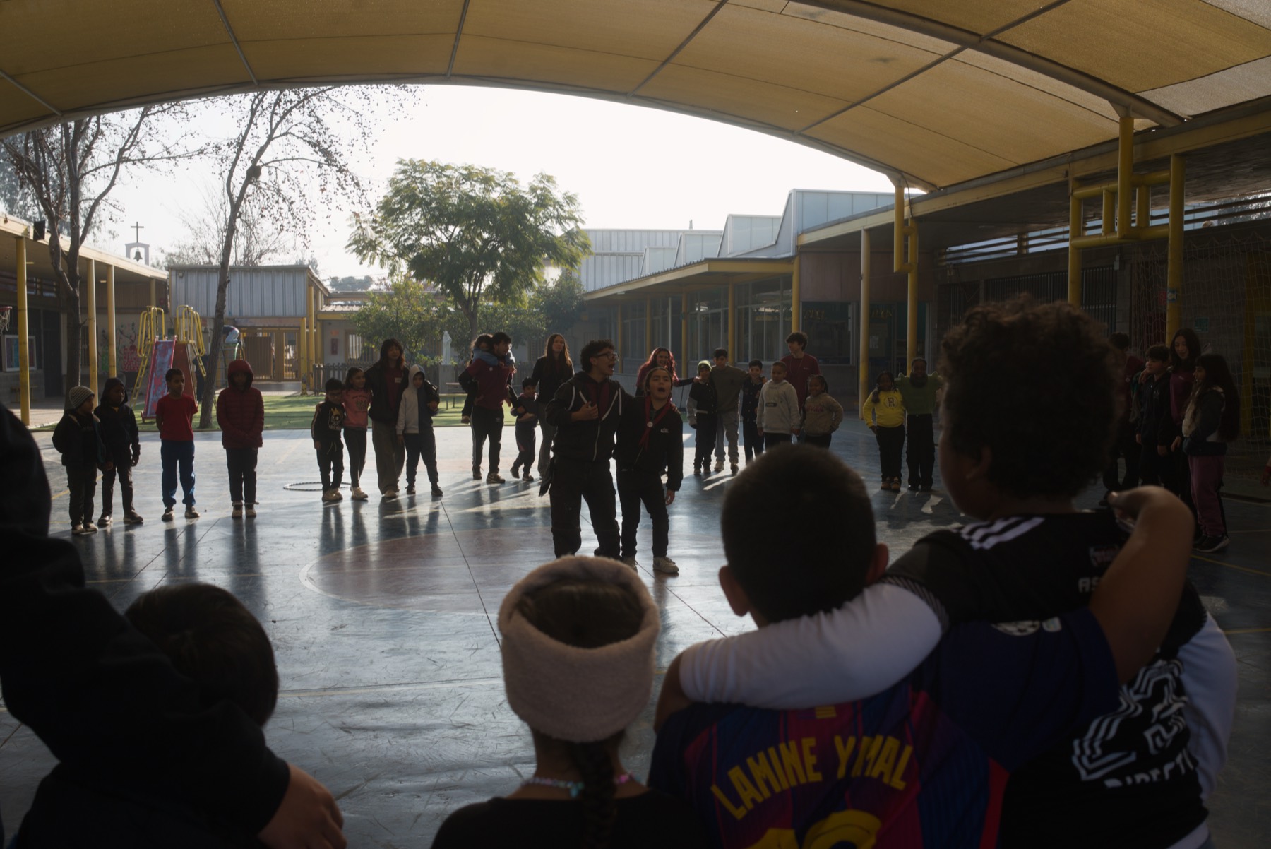Niños y monitores en círculo en el patio del colegio durante las Colonias de Invierno