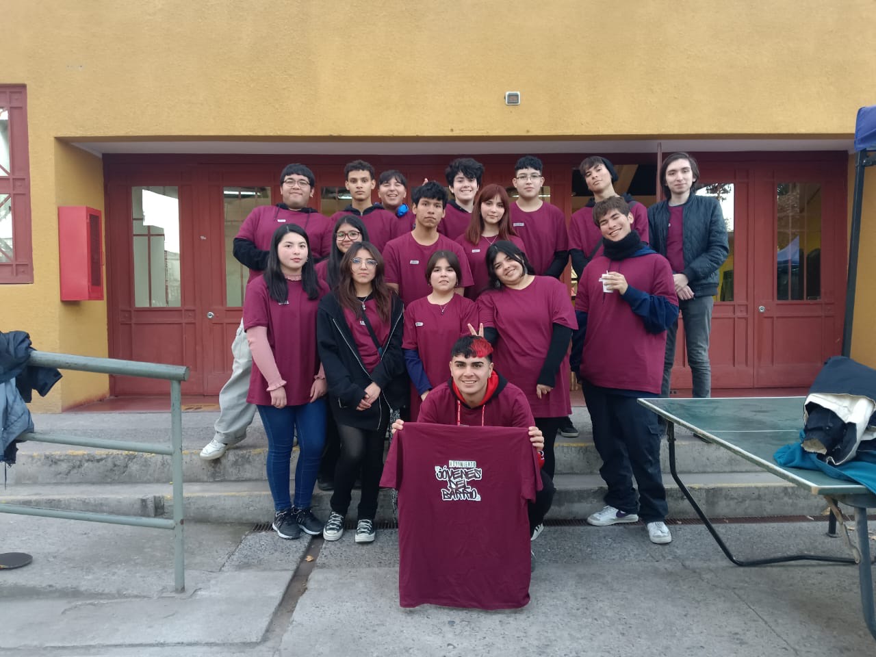El equipo fundador de Jóvenes del Barrio reunido, sosteniendo la primera polera con el logo